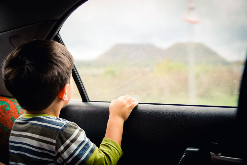 Ребенок смотрит в окно в машине